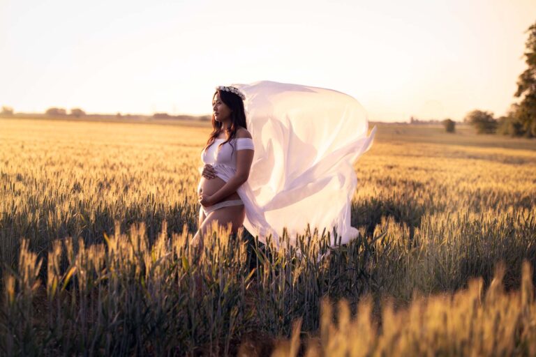 femme enceinte dans un champ avec grand voile