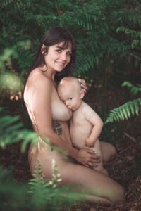 jeune femme allaitant son enfant en forêt
